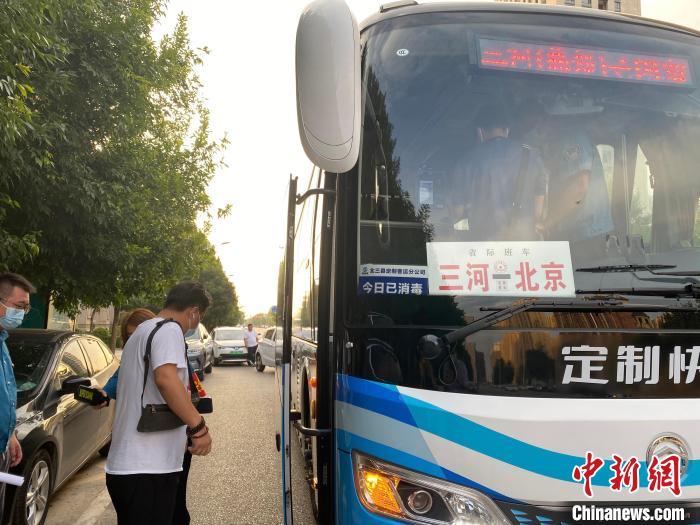 资料图：三河市某小区门口，乘客正在排队等候乘坐通勤定制快巴。 高澍 摄