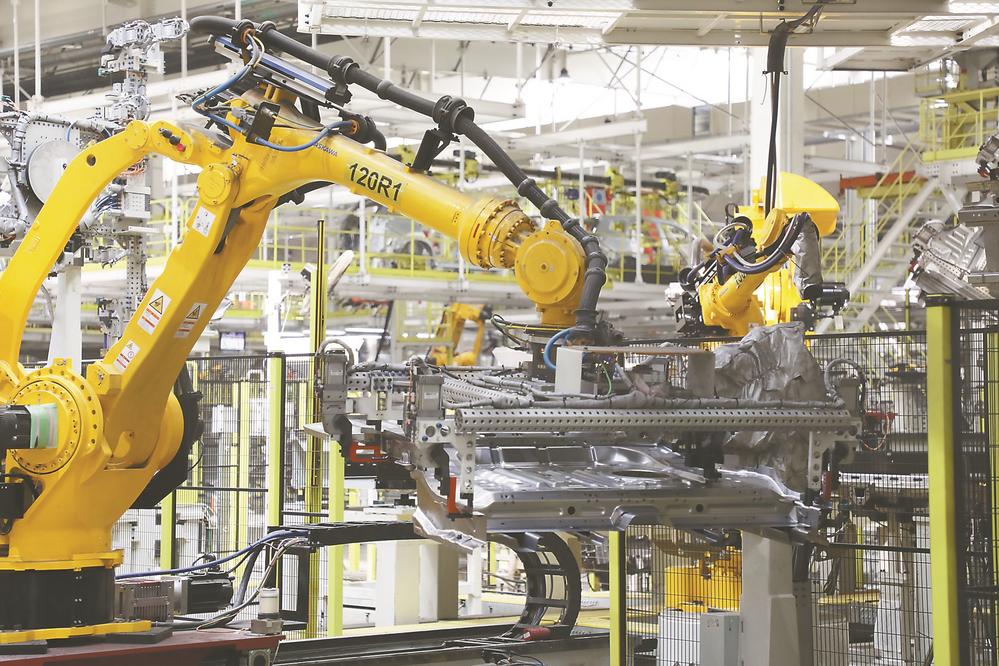 2月14日，在位于芜湖市的奇瑞汽车智能网联超级一工厂生产车间，机器人在进行安装作业。李季摄