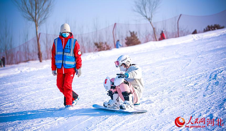 在河北省滦州市的一家滑雪场，孩子在教练的指导下体验单板滑雪。 李阳摄