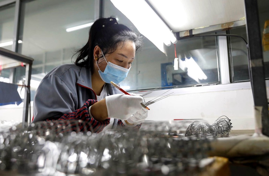 5月12日，在河南省平顶山市宝丰县一家眼镜加工企业，工人在做眼镜框。何五昌摄