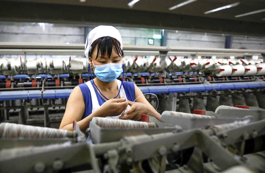5月12日，工人在河南省平顶山市宝丰县一棉纺织企业车间赶制订单。何五昌摄