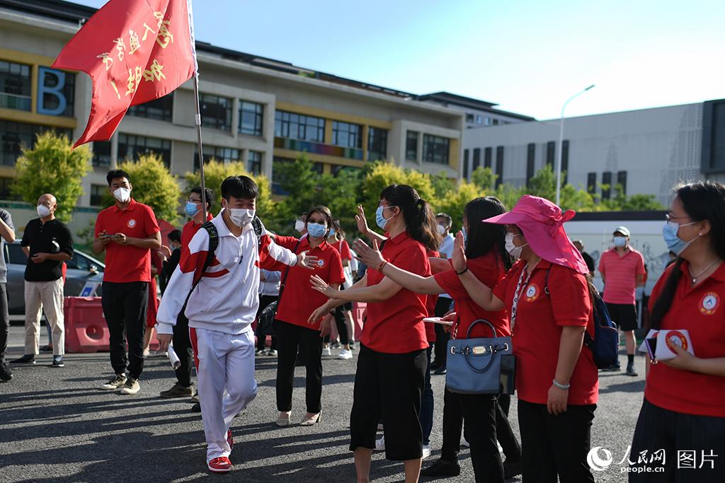 6月7日，在北京市人大附中通州校区考点，考生与送考老师击掌加油。人民网记者 翁奇羽摄