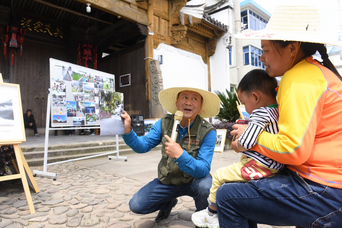 5月17日，在建德市航头镇航川村，“文艺村长”范胜利点评村民陆庆娟的手机摄影作品。该市在各镇街推行“文艺村长”工作制度，将有意愿、热情的文艺工作者分派到农村担任“文艺村长”。新华社记者 翁忻旸 摄