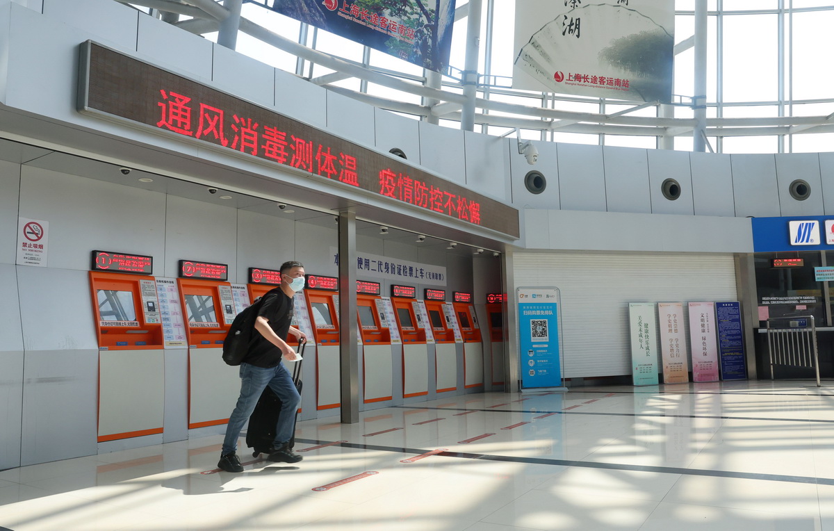 7月5日，在上海长途客运南站，一位旅客在自助取票机前完成取票准备进站。