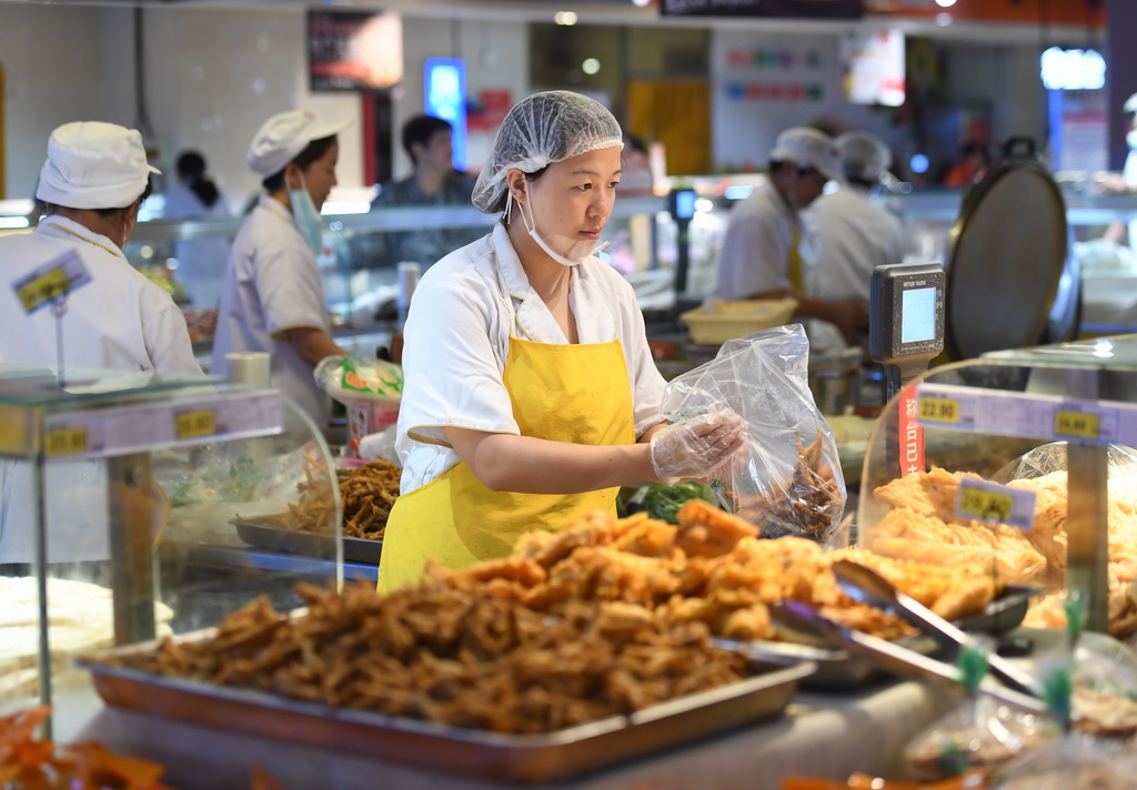 8月10日，涿州市惠友超市钻石广场店工作人员在为顾客打包食品。