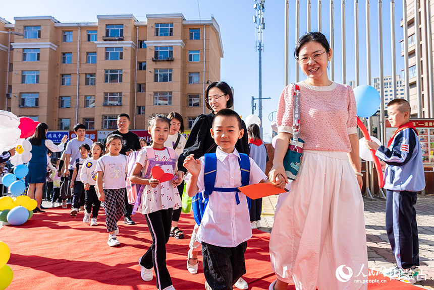 呼和浩特市玉泉区南柴火市街小学，一年级新生在家长的带领下步入校园。丁根厚摄