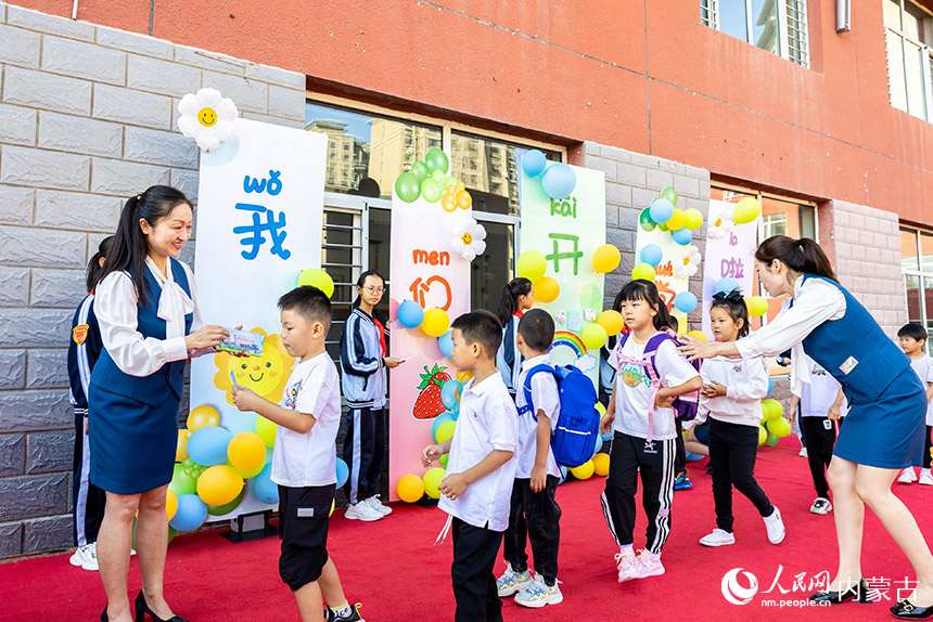 呼和浩特市玉泉区南柴火市街小学，学校老师为一年级新生送上明信片。丁根厚摄