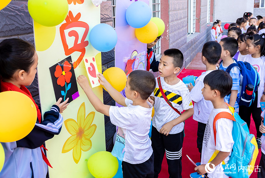 呼和浩特市玉泉区南柴火市街小学的一年级新生在粘贴心愿卡。丁根厚摄