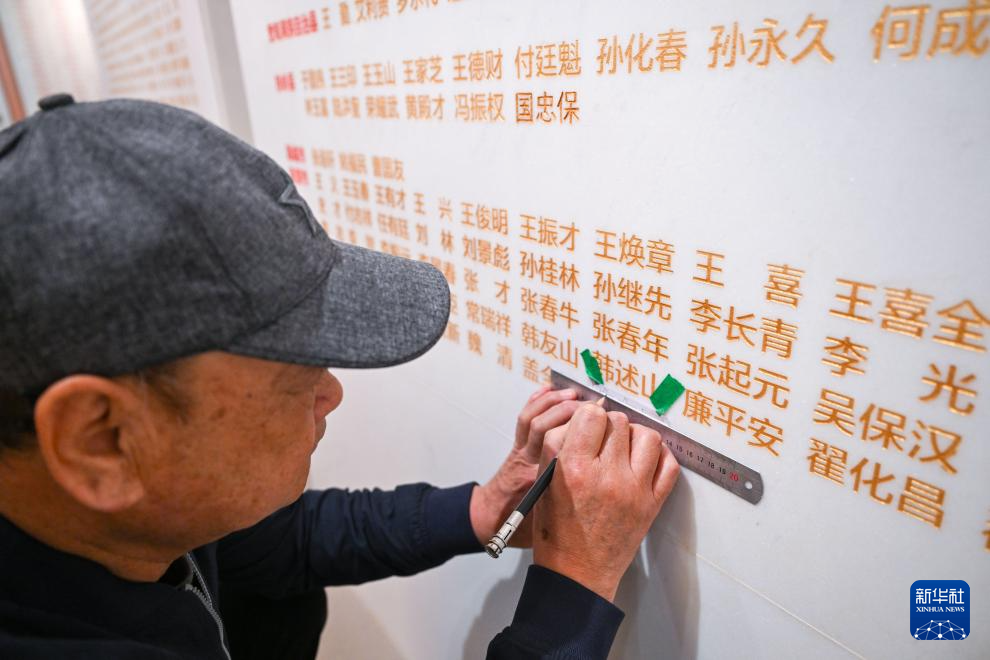 3月29日，在平津战役纪念馆，工作人员准备将新确认的烈士姓名刻在烈士墙上。新华社记者 孙凡越 摄