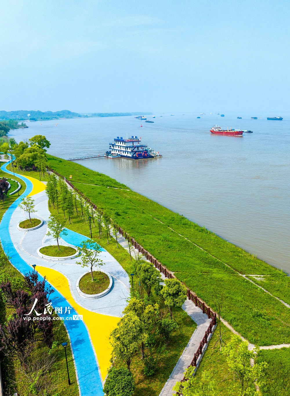 2024年4月23日，安徽省芜湖市繁昌区新港镇滨江公园，水清岸绿，风景如画，船舶在江面上有序航行。