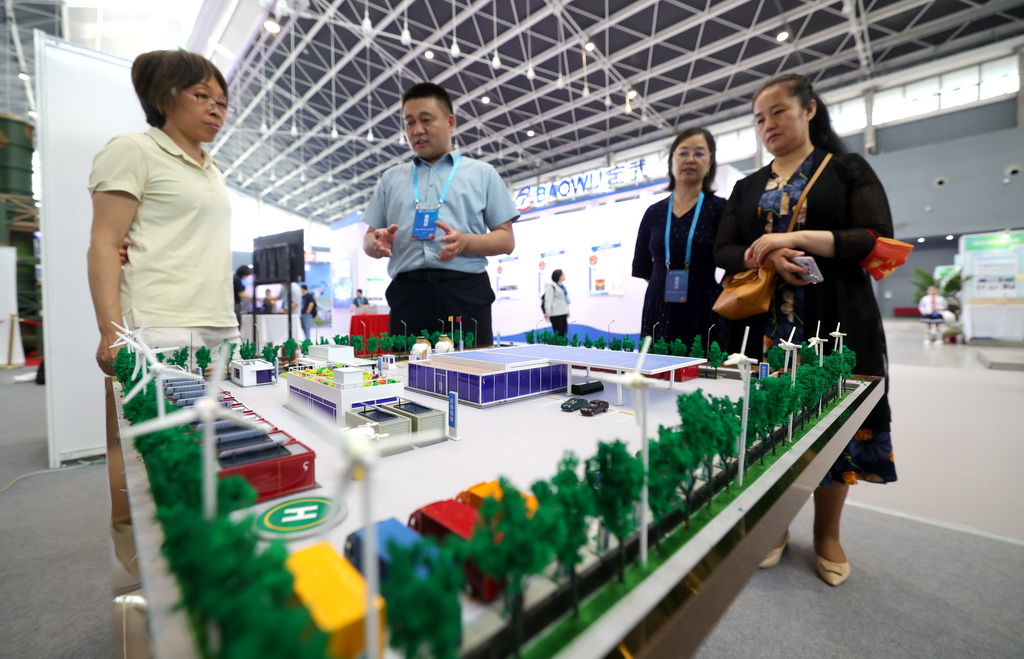 5月22日，在第27届全国发明展览会现场，参展商（左二）为观众介绍新能源气候应用系统设计。新华社发（梁子栋摄）