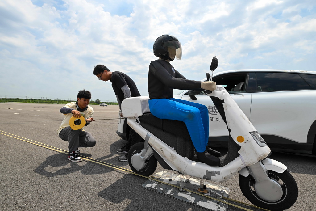 6月14日，测试人员对一款智能网联汽车转弯规避非机动车主动安全测试结果进行测量。