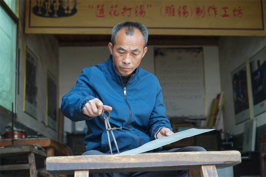 国家级非遗锡雕（莲花打锡）代表性传承人刘建强在制作锡雕的原材料。人民网 孔文进摄