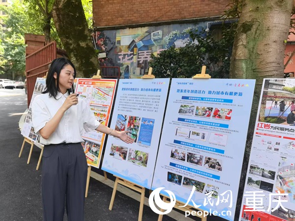 陈丹介绍沙坪坝区城市箱体美化志愿服务项目情况。人民网记者 冯文彦摄