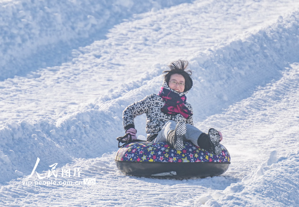 2024年12月14日，新疆昌吉回族自治州昌吉市努尔加滑雪场，游客在滑雪圈。