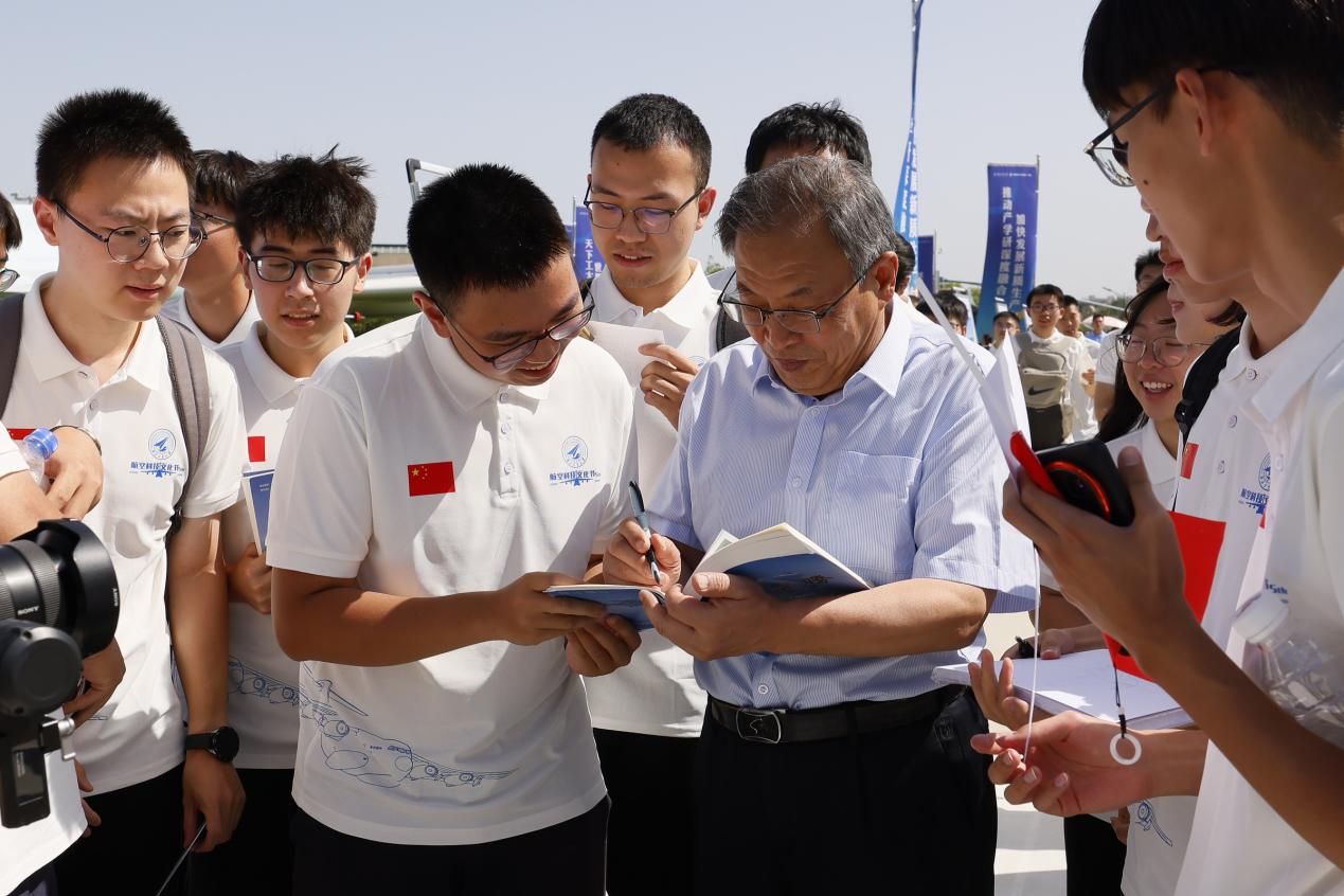 西工大学子们争相向唐长红索要签名，思政课秒变“追星现场”。 校方供图