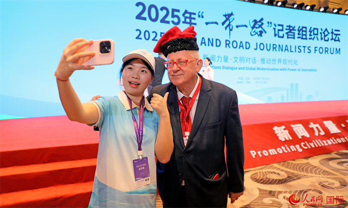 论坛期间，当地志愿者同外媒嘉宾自拍留念。人民网记者 赵益普摄