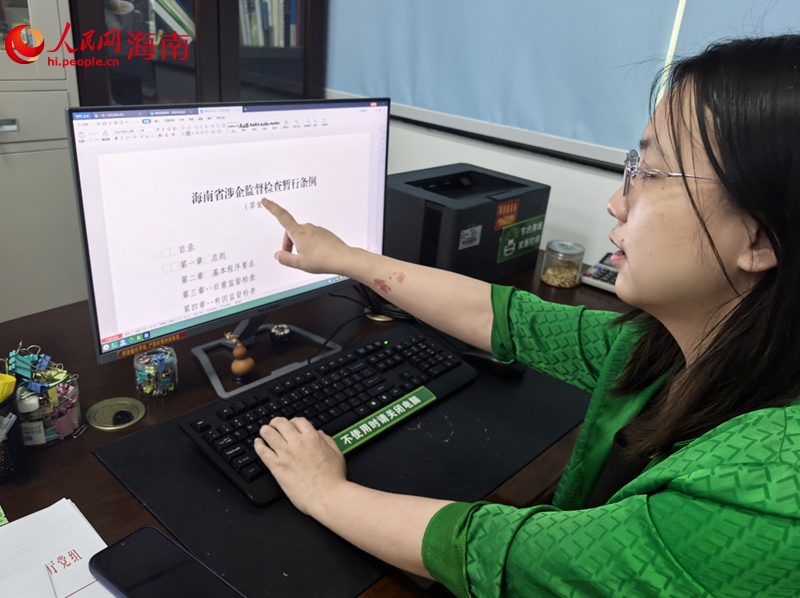 冯译向记者展示海南优化营商环境的最新成果。人民网记者 毛雷摄