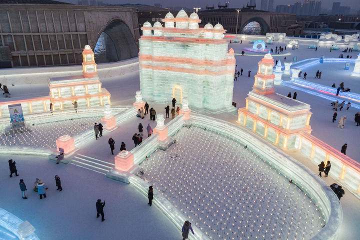 2023年2月1日，游客在哈尔滨冰雪大世界园区冰雪景观《胜利之城》周边游玩，该冰雪景观以印度的法塔赫布尔西格里城为原型设计建造（无人机照片）。此届哈尔滨冰雪大世界将上合组织成员国的特色建筑以冰雪景观的形式呈现。新华社记者 谢剑飞 摄