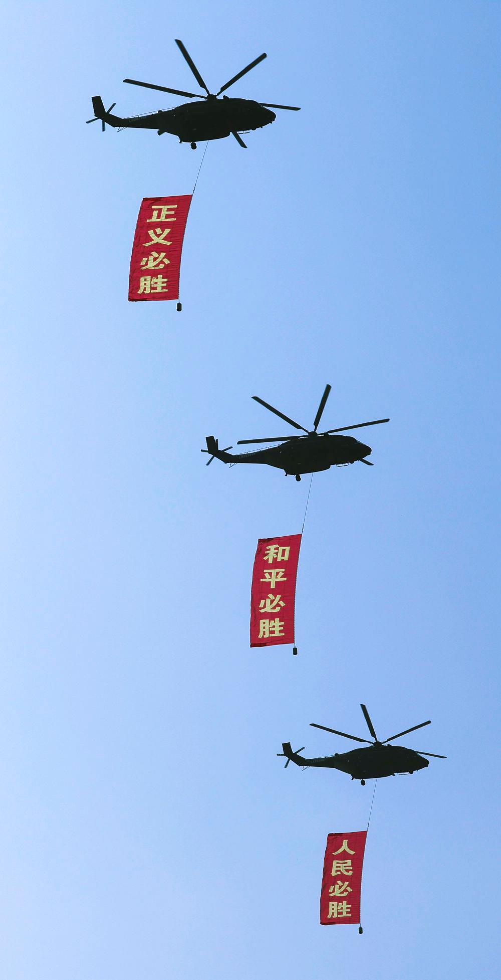 △2025年9月3日，纪念中国人民抗日战争暨世界反法西斯战争胜利80周年大会在北京隆重举行。这是空中护旗梯队通过天安门广场，3架直-8L运输直升机分别悬挂“正义必胜”“和平必胜”“人民必胜”条幅。